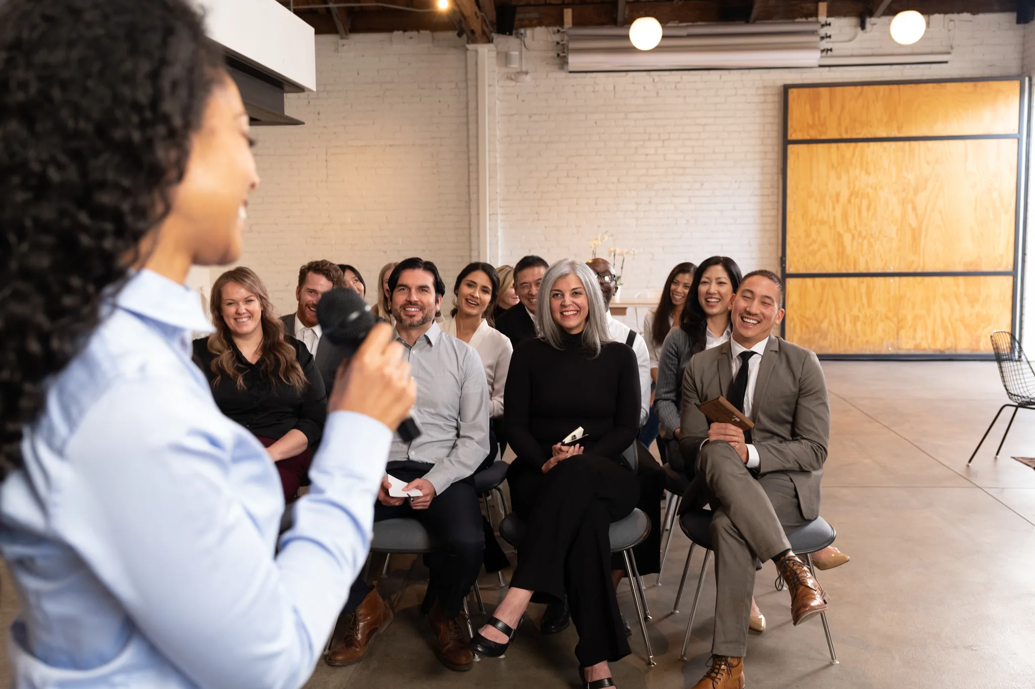 A Toastmasters member speaks to a seated audience during a contest